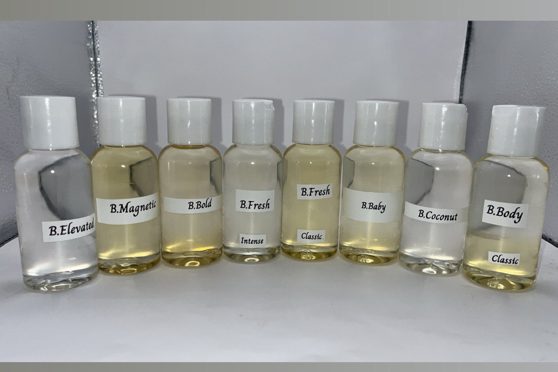 Row of small glass bottles with labels on a white background
